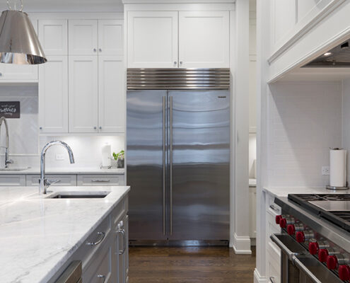 A stainless steel refrigerator in a white home kitchen