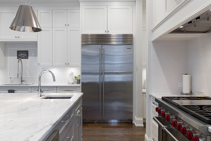 A stainless steel refrigerator in a white home kitchen